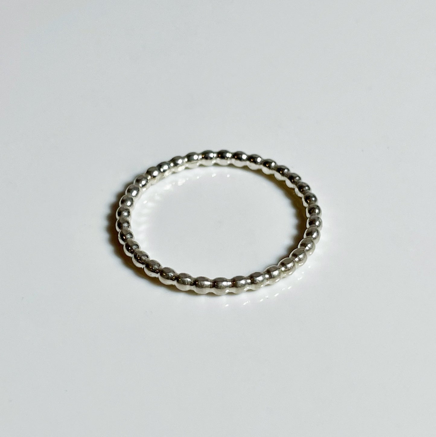 A sterling silver stacker ring with a textured band, displayed against a white background.
