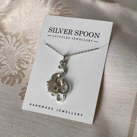 Silver necklace on a 'Silver Spoon' branded card with a textured fabric background

